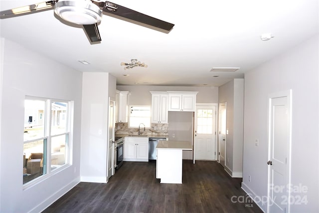 kitchen featuring white cabinets, dark hardwood / wood-style floors, stainless steel appliances, sink, and a center island