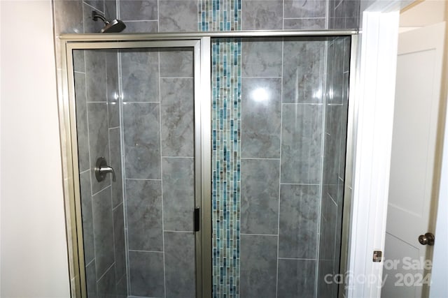 bathroom featuring a shower with door