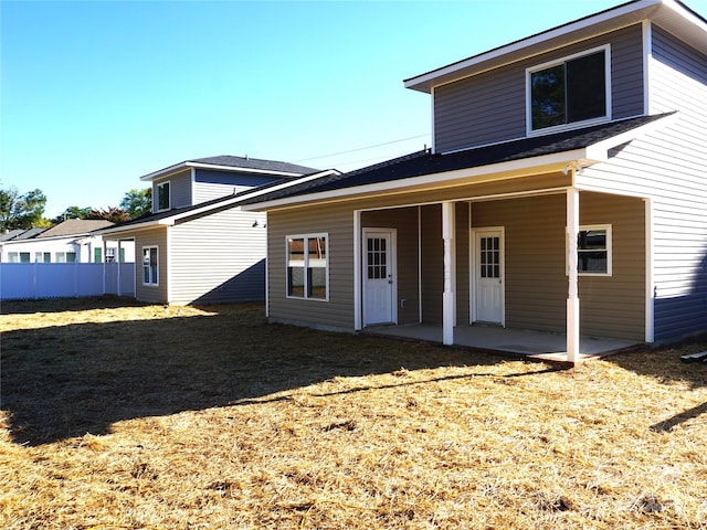 back of house with a patio area and a lawn