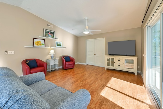 living room with baseboards, visible vents, ceiling fan, wood finished floors, and vaulted ceiling