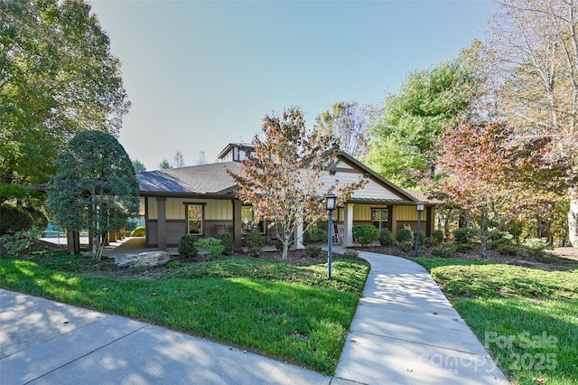 view of front of property featuring a front lawn, board and batten siding, and a shingled roof