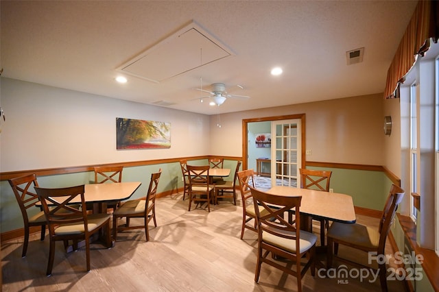 dining area with visible vents, light wood-type flooring, attic access, and baseboards