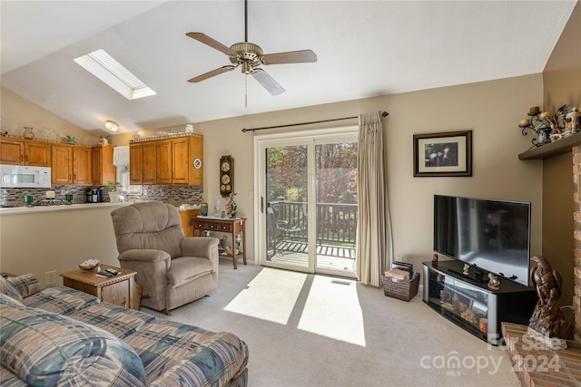 carpeted living room featuring ceiling fan and vaulted ceiling with skylight