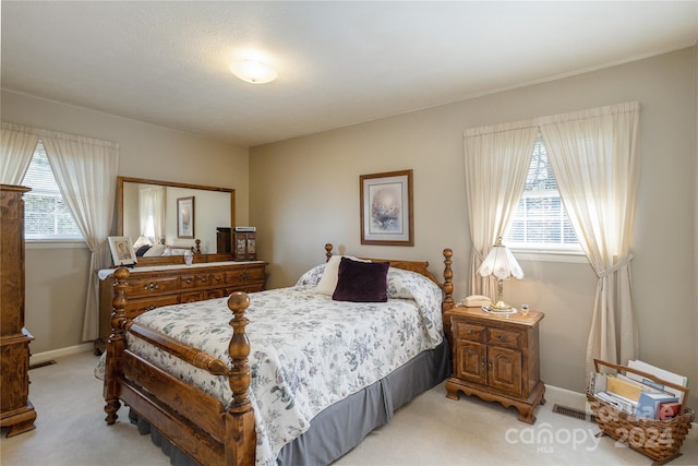 bedroom featuring light carpet and multiple windows