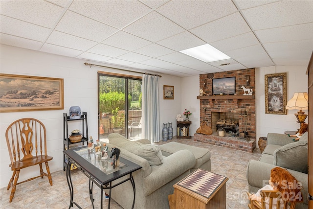 living room featuring a brick fireplace and a paneled ceiling