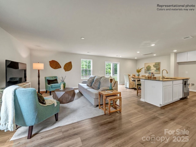 living room with sink and light hardwood / wood-style flooring