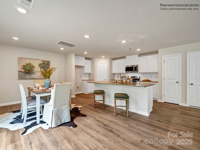 dining area with light hardwood / wood-style floors and sink