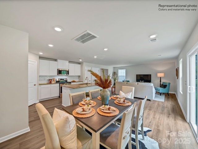 dining area with light hardwood / wood-style floors and sink