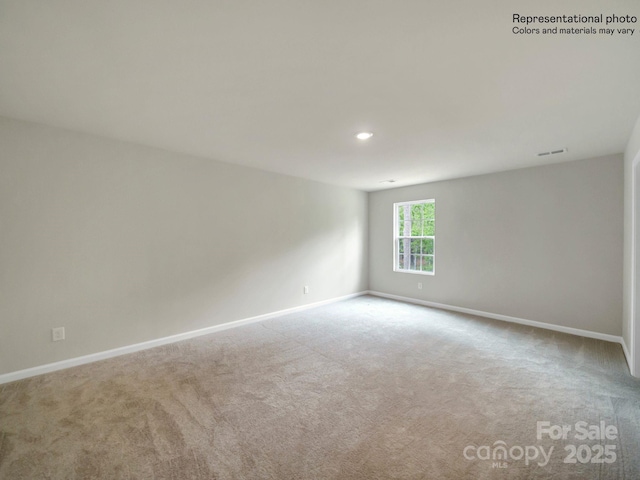 spare room featuring light colored carpet