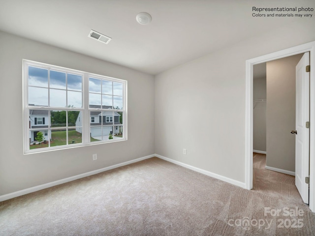 spare room featuring light carpet