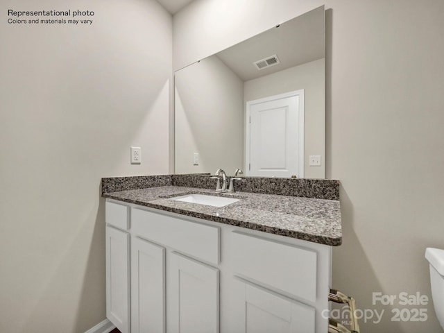 bathroom featuring toilet and vanity