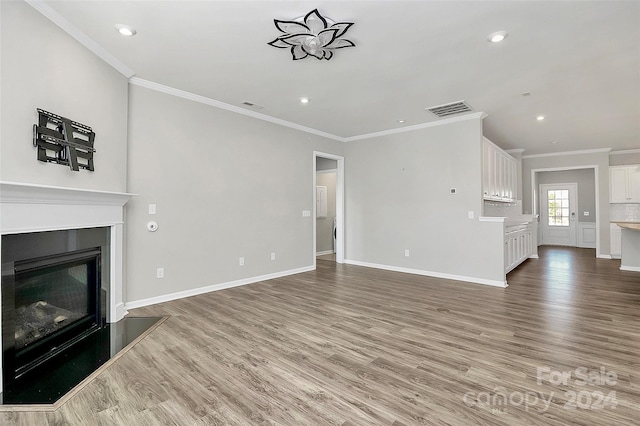 unfurnished living room with crown molding and light wood-type flooring