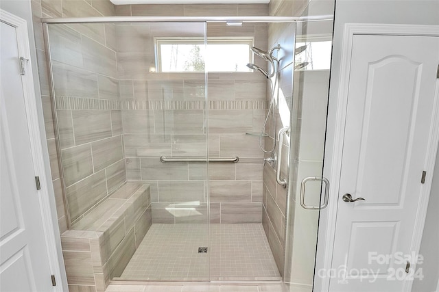 bathroom featuring a shower with shower door