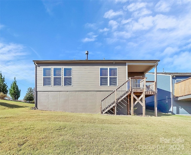 rear view of house featuring a deck and a lawn