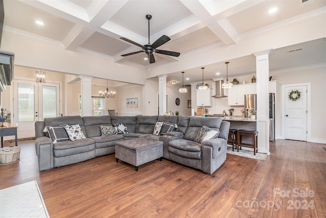 living room featuring coffered ceiling, beamed ceiling, dark wood-type flooring, crown molding, and ceiling fan with notable chandelier