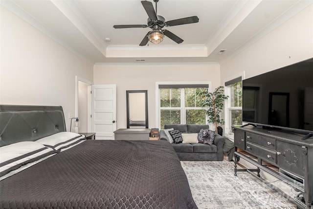 bedroom with ceiling fan, crown molding, and a tray ceiling