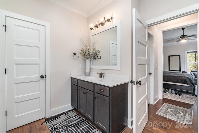 bathroom featuring vanity, hardwood / wood-style floors, crown molding, and ceiling fan