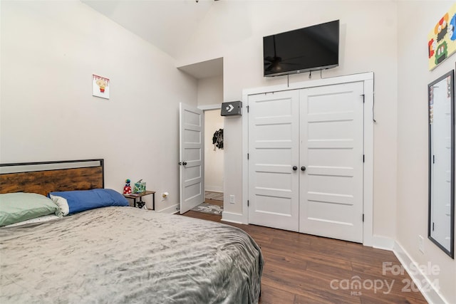 bedroom featuring lofted ceiling, a closet, and dark hardwood / wood-style flooring