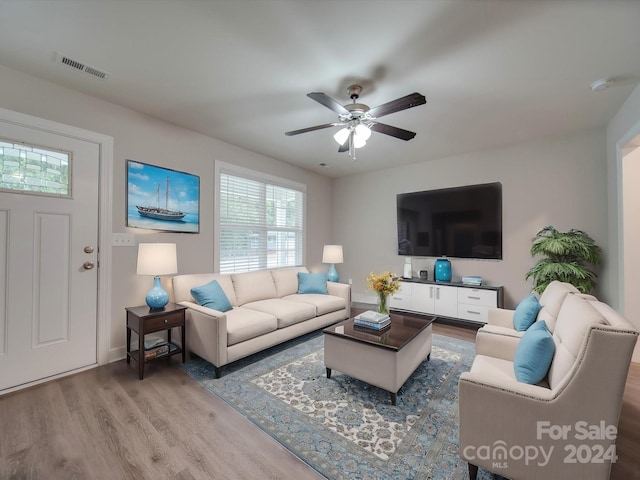 living room featuring light wood-type flooring and ceiling fan