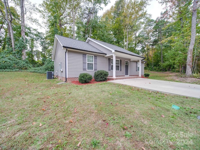 single story home featuring cooling unit and a front lawn