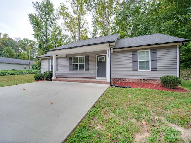 ranch-style home with a front yard and covered porch