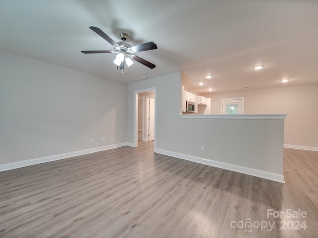 unfurnished room with ceiling fan and light wood-type flooring