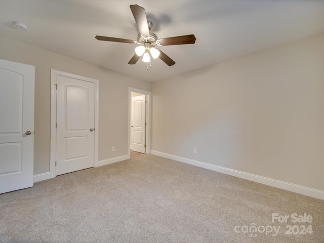 unfurnished bedroom featuring light carpet and ceiling fan