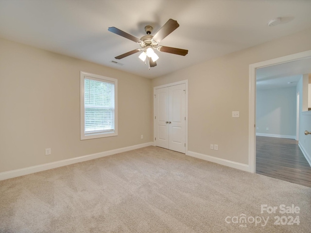 empty room featuring light carpet and ceiling fan