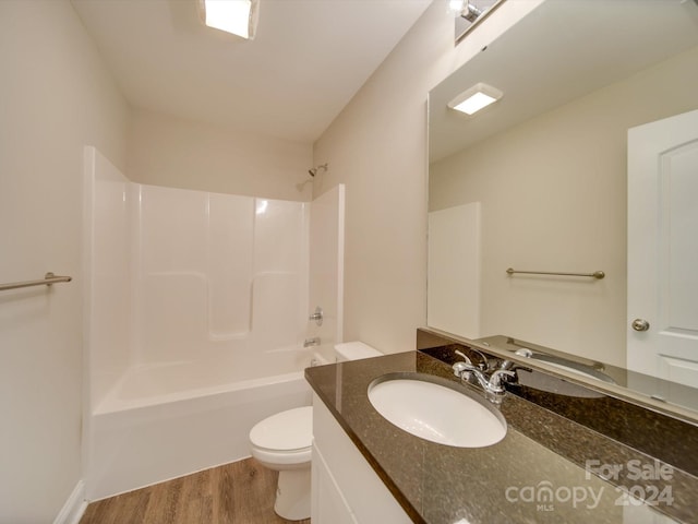 full bathroom featuring vanity, washtub / shower combination, hardwood / wood-style flooring, and toilet