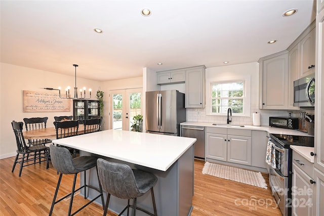 kitchen featuring stainless steel appliances, gray cabinetry, and sink