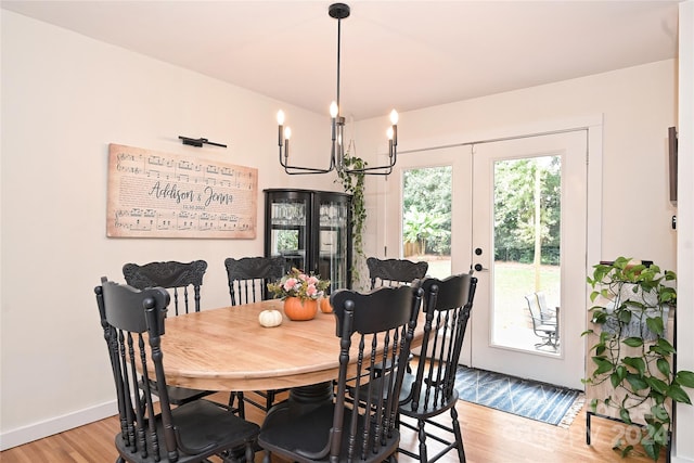 dining space featuring a chandelier, french doors, and light hardwood / wood-style floors