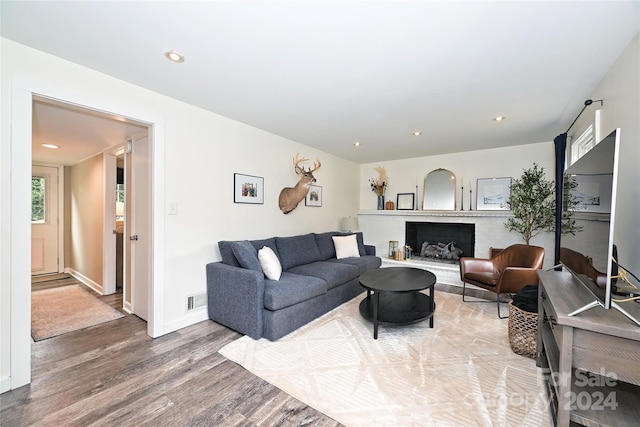 living room featuring a brick fireplace and hardwood / wood-style flooring