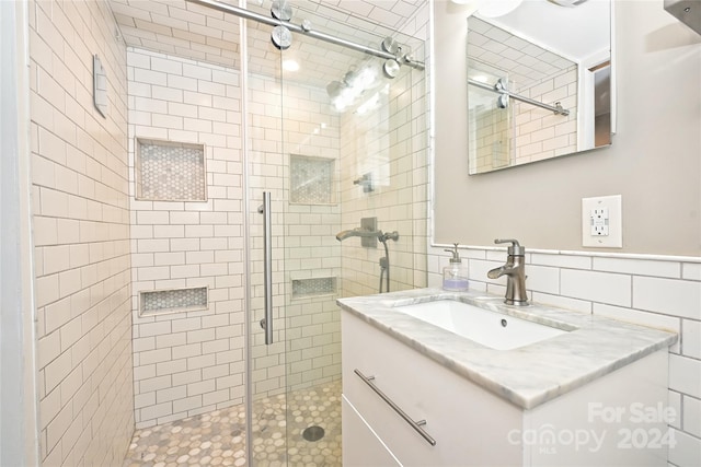 bathroom featuring vanity, an enclosed shower, and tile walls