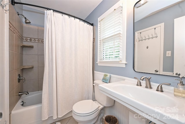 full bathroom with sink, tile patterned flooring, shower / bath combination with curtain, and toilet