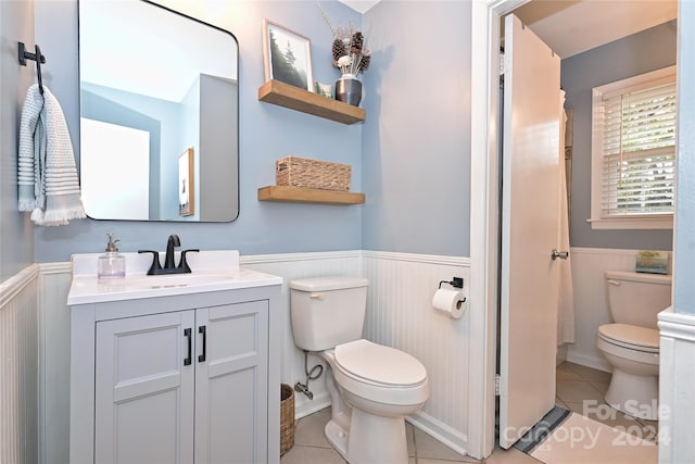 bathroom with tile patterned flooring, vanity, and toilet