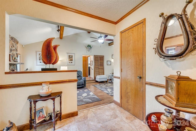 corridor featuring ornamental molding, a textured ceiling, light wood-type flooring, and vaulted ceiling