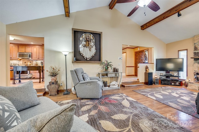 living room featuring light hardwood / wood-style floors, high vaulted ceiling, and ceiling fan