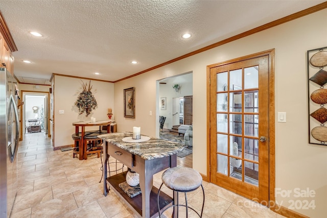 dining space featuring ornamental molding and a textured ceiling