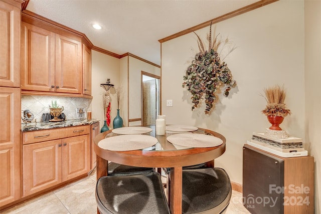 tiled dining room featuring crown molding