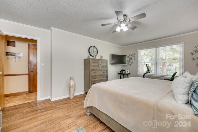 bedroom with ornamental molding, a textured ceiling, light wood-type flooring, and ceiling fan