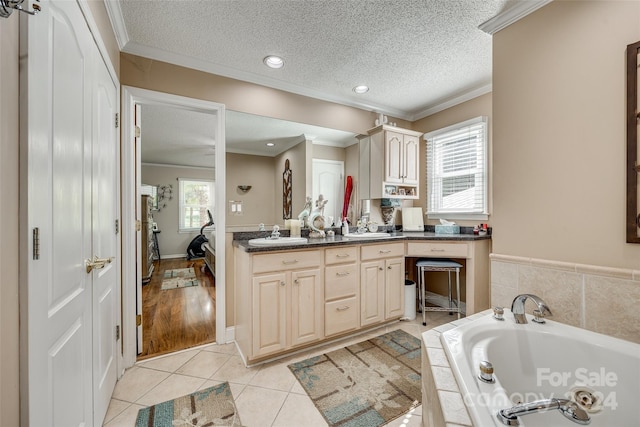 bathroom with a washtub, vanity, tile patterned floors, and plenty of natural light