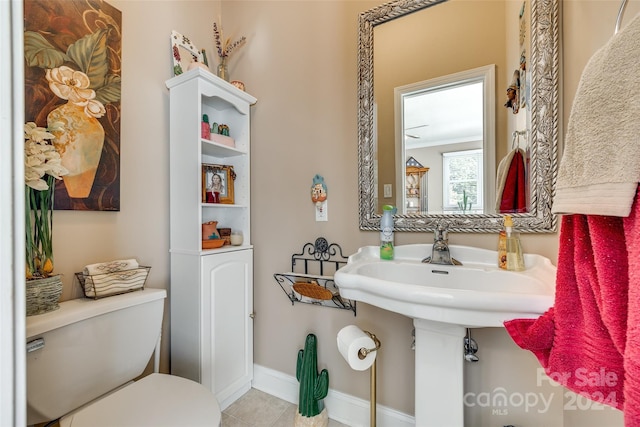 bathroom featuring toilet, ornamental molding, and tile patterned floors