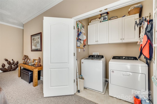 laundry area with cabinets, light tile patterned floors, a textured ceiling, separate washer and dryer, and crown molding