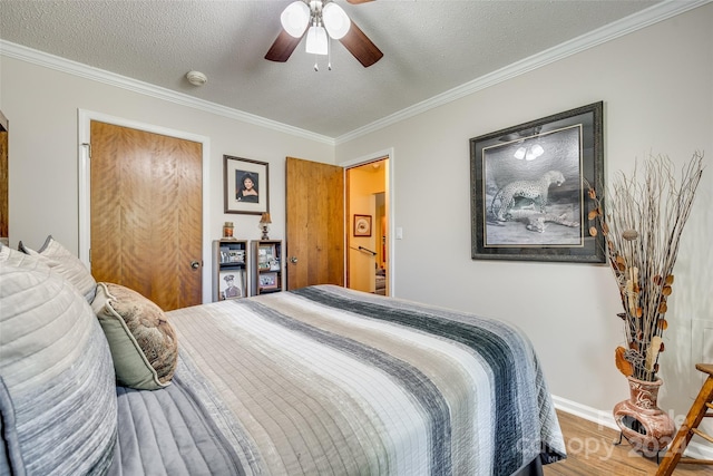 bedroom featuring crown molding, a textured ceiling, wood-type flooring, and ceiling fan