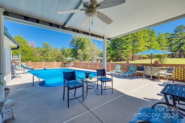 view of patio featuring a fenced in pool and ceiling fan