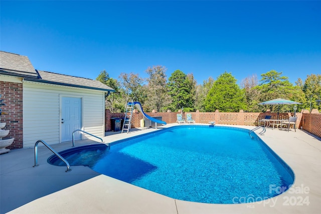 view of swimming pool with a patio and a water slide