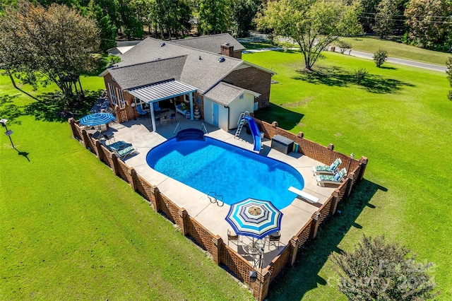 view of pool with a yard, a diving board, and a patio