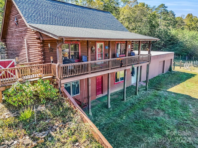 rear view of house with a wooden deck and a lawn