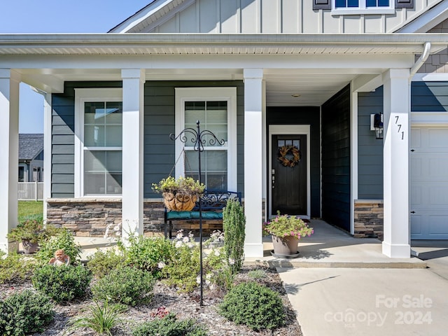 view of exterior entry with covered porch and a garage