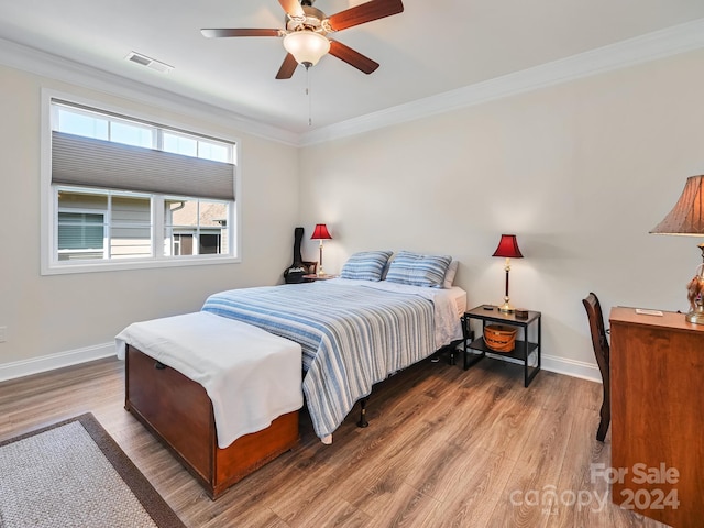 bedroom featuring hardwood / wood-style floors, crown molding, and ceiling fan